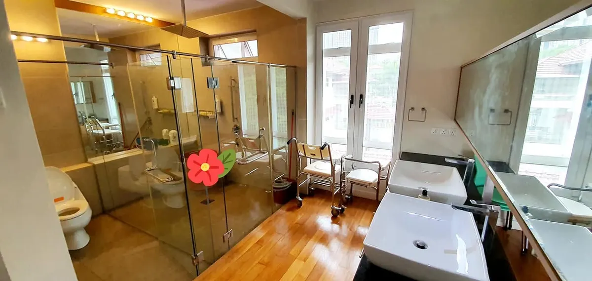 Accessible bathroom with shower chairs and grab bars at Elderly Gardens Care Centre