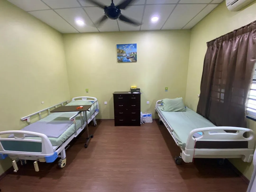 Twin sharing room at Elders Home Plus with two adjustable beds, chest of drawers and ceiling fan