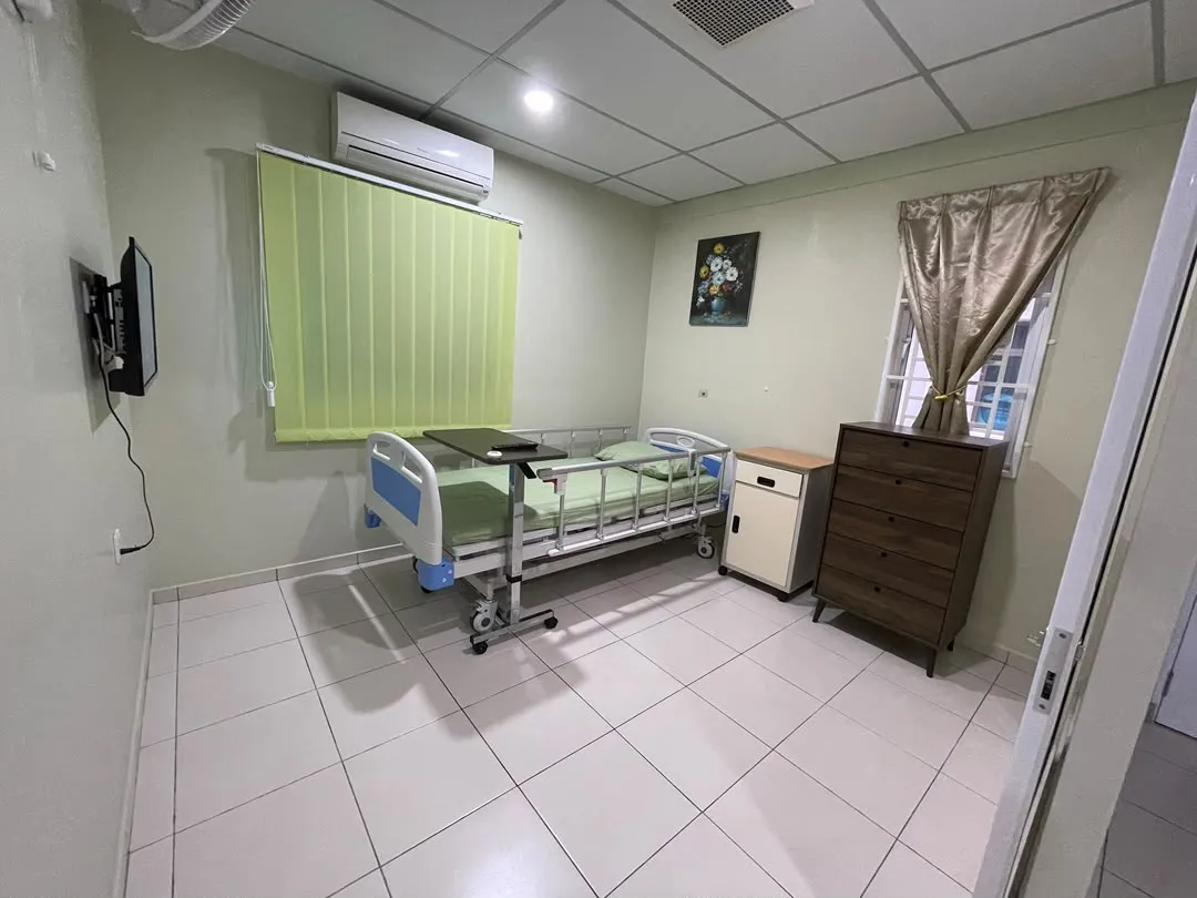 Single-bed room at Elders Home Plus with adjustable bed, over-bed table, wall-mounted television and air conditioning