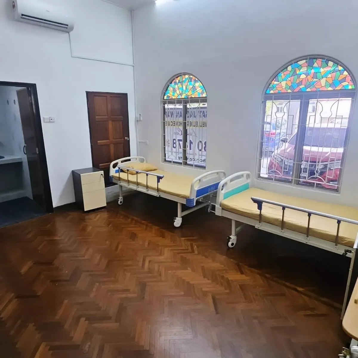Resident room with care beds and arched windows at Prowell Elderly Home Care Centre