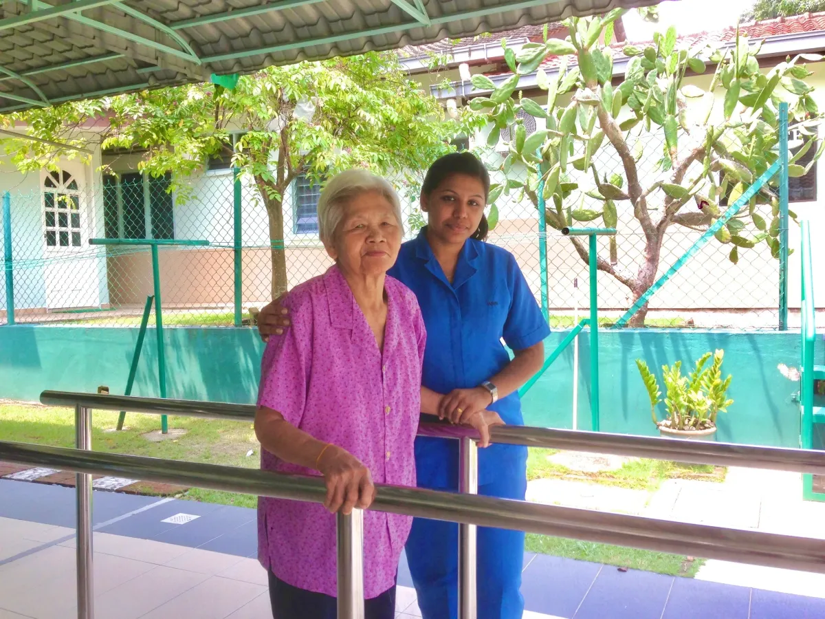 Resident with caregiver at City Heart Care outdoor walkway