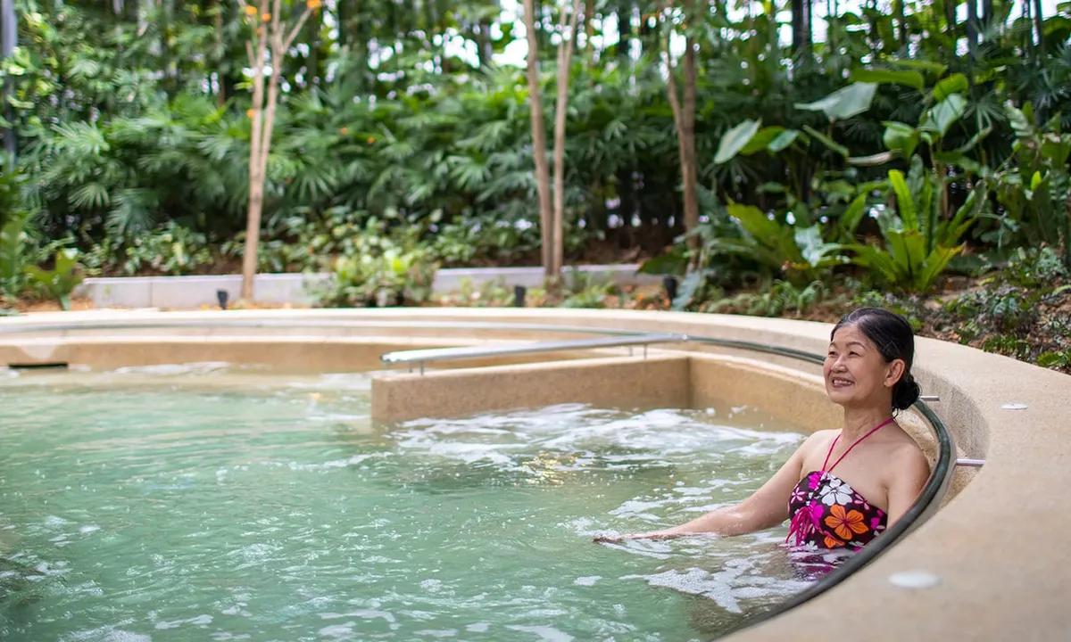 Resident relaxing in the outdoor jacuzzi garden at Komune Care