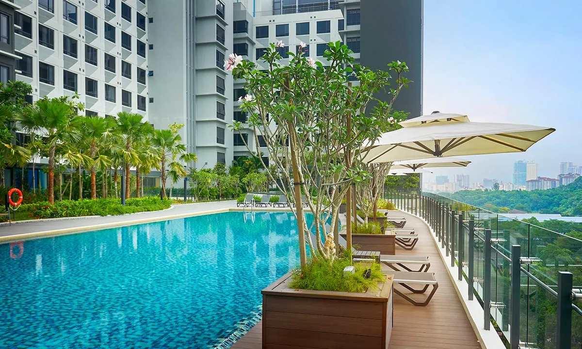 Infinity pool with sun loungers at Komune Care Cheras